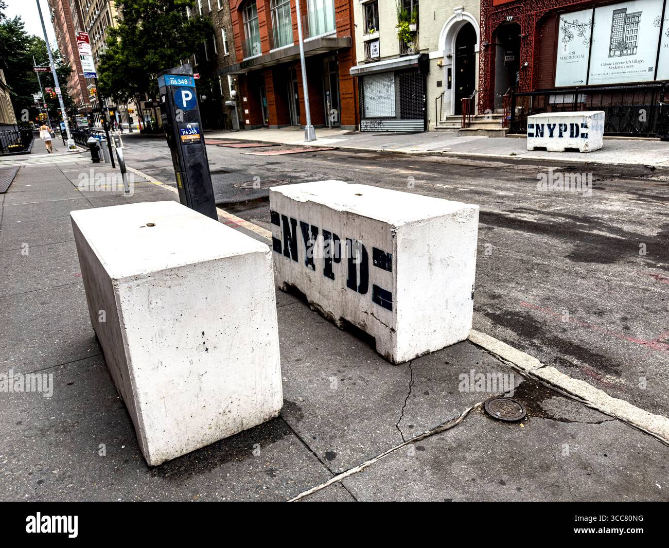 nypd bollards on macdougal street serve as physical barriers to prevent unauthorized vehicle access and protect pedestrians and property 3CC80NG