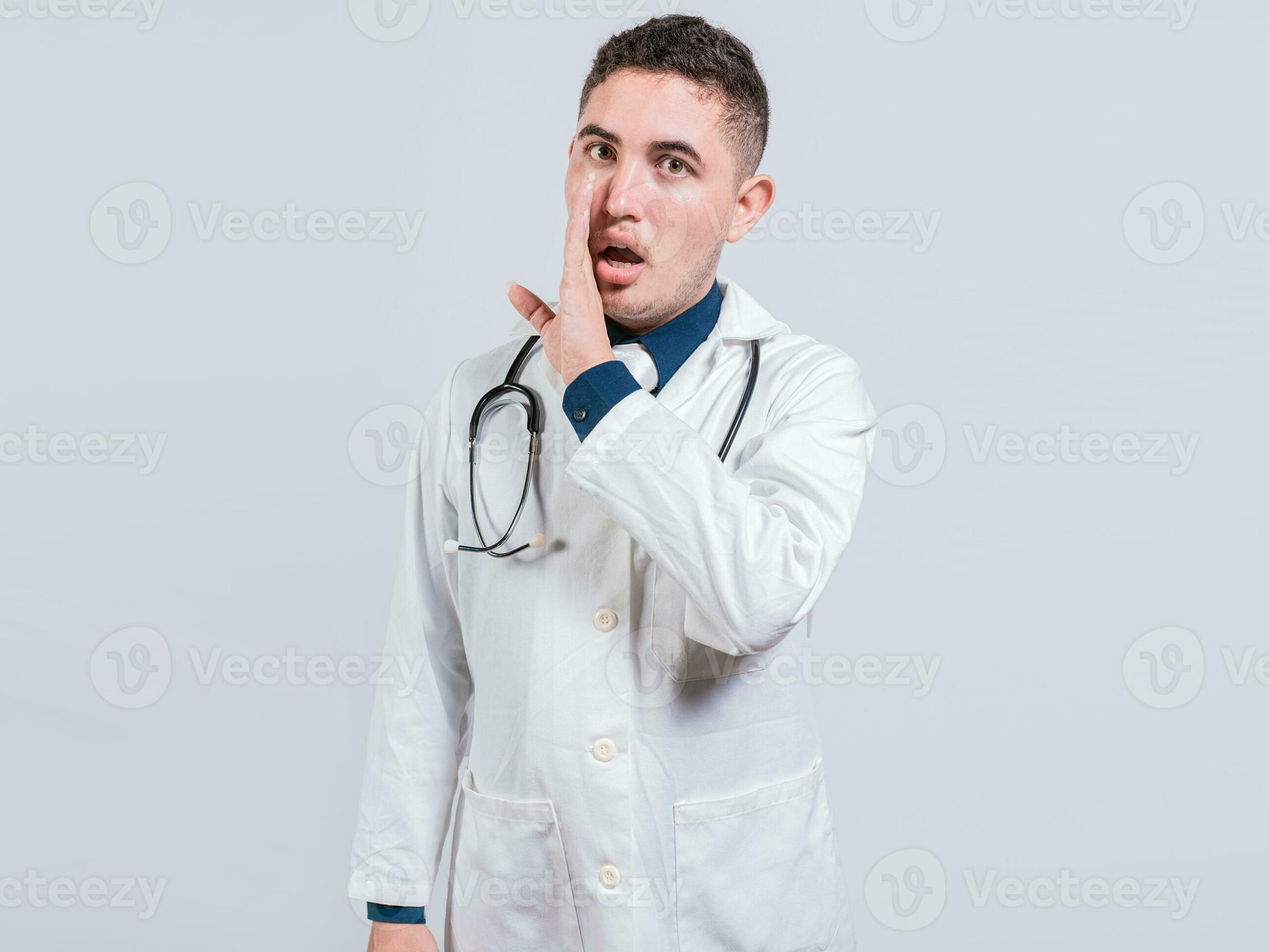 young doctor whispering a secret on isolated background handsome doctor telling a gossip isolated doctor telling a secret photo scaled